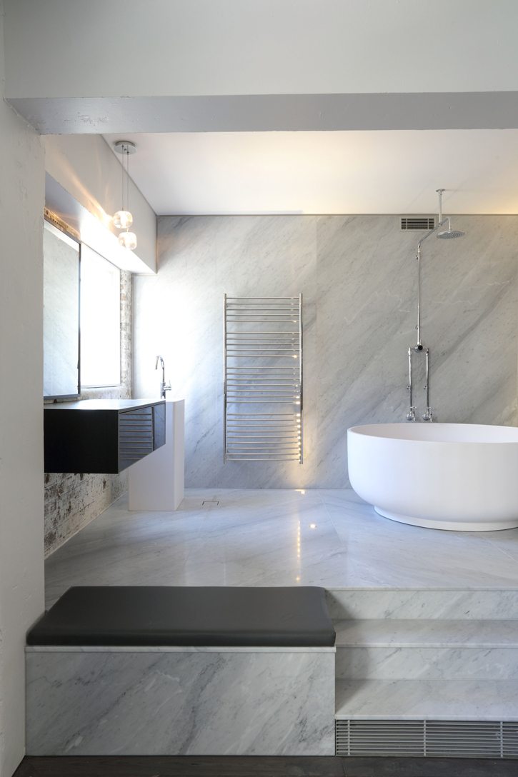 white marble bathroom design with large white bathtub