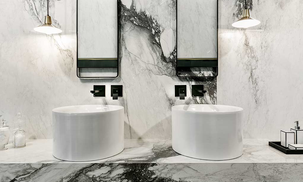 beautiful white marble bathroom with two round sinks 