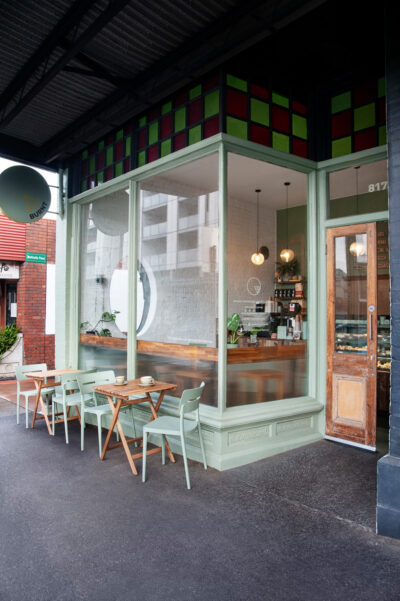 Outdoor café seating with sage green chairs and timber tables outside Better Burnt Hawthorn.