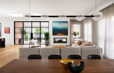 Open-plan living room with modern furniture, artwork, and layered textures.