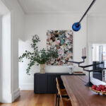 Modern Australian dining room with timber table, leather chairs, and abstract artwork.