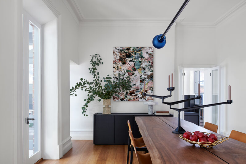Modern Australian dining room with timber table, leather chairs, and abstract artwork.