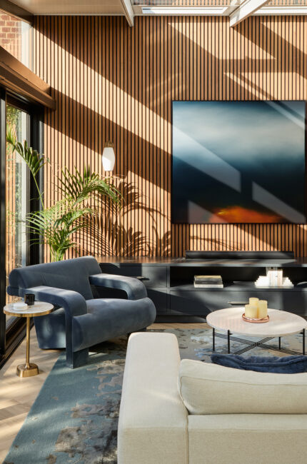 Australian living room with timber slatted wall, modern armchair, and layered natural light.