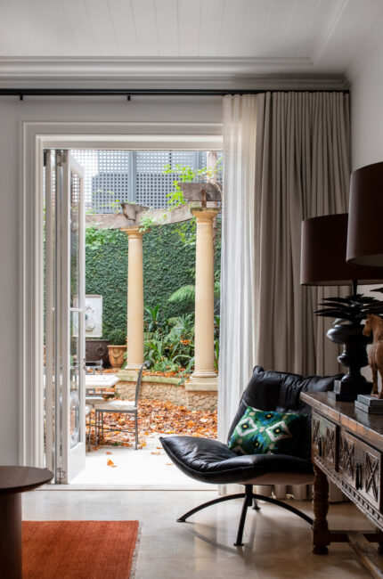 Living room with open doors to courtyard garden, blending indoor and outdoor Australian design.