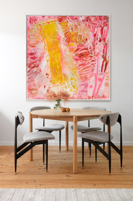 Contemporary dining room with timber table, sculptural chairs, and large abstract pink artwork.