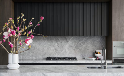 Contemporary kitchen with marble benchtop, black cabinetry, and pink floral styling.
