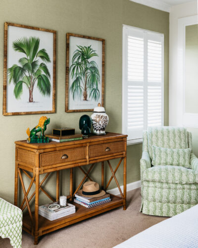 Green wallpaper bedroom with timber accents and patterned armchair.