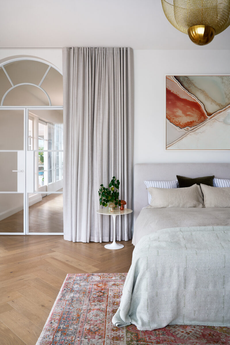 Modern Australian bedroom with neutral tones, textured bedding, and abstract wall art.
