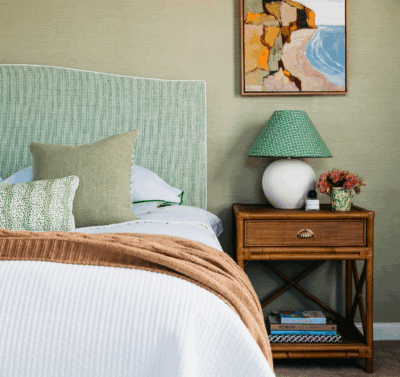 Hamptons bedroom in Brisbane with soft green tones, woven textures and classic bedside styling by The Stylesmiths.
