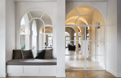 Hamptons-style entryway in a Brisbane home with arched glazing, built-in window seat and soft neutral palette by The Stylesmiths.