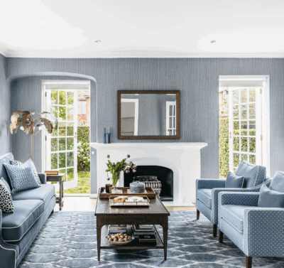 Hamptons living room in Melbourne by The Stylesmiths featuring blue upholstery, classic fireplace and refined coastal styling