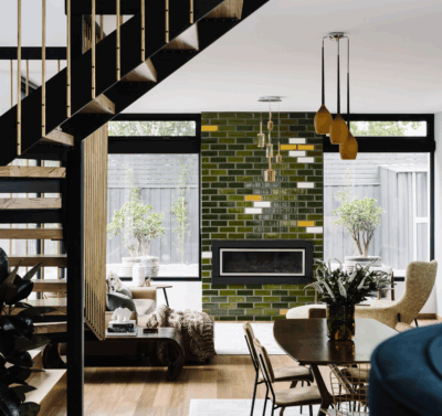 Contemporary luxury living space in Brisbane with timber staircase and green tiled fireplace by The Stylesmiths